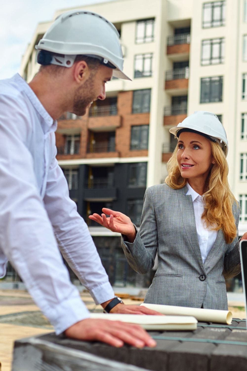 Elegant building supervisor talking to builders outside